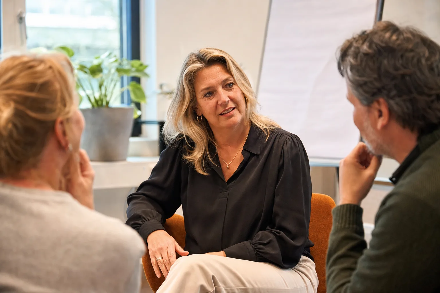 Teamleider in gesprek met haar team tijdens een leiderschapstraining